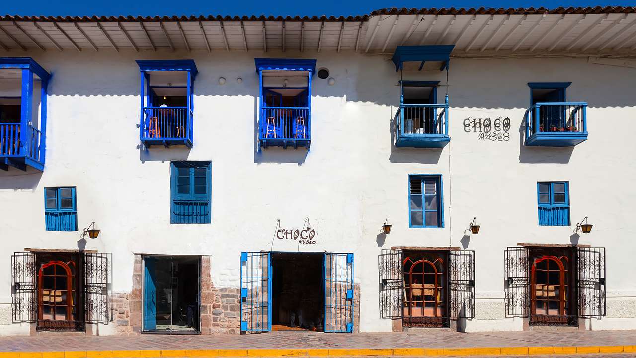 A facade of a white building with colorful doors and windows