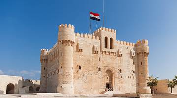 The medieval fort Citadel of Qaitbay with a flag on top on a bright sunny day