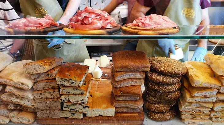 An array of bread displayed in a glass cabinet