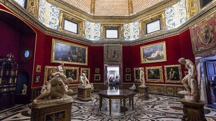 A museum adorned with several sculptures and paintings in golden frames