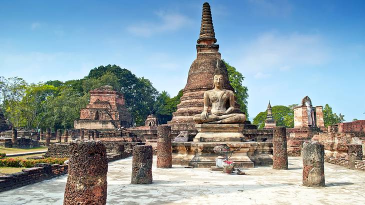 Ancient temple ruins with a Buddha statue in front