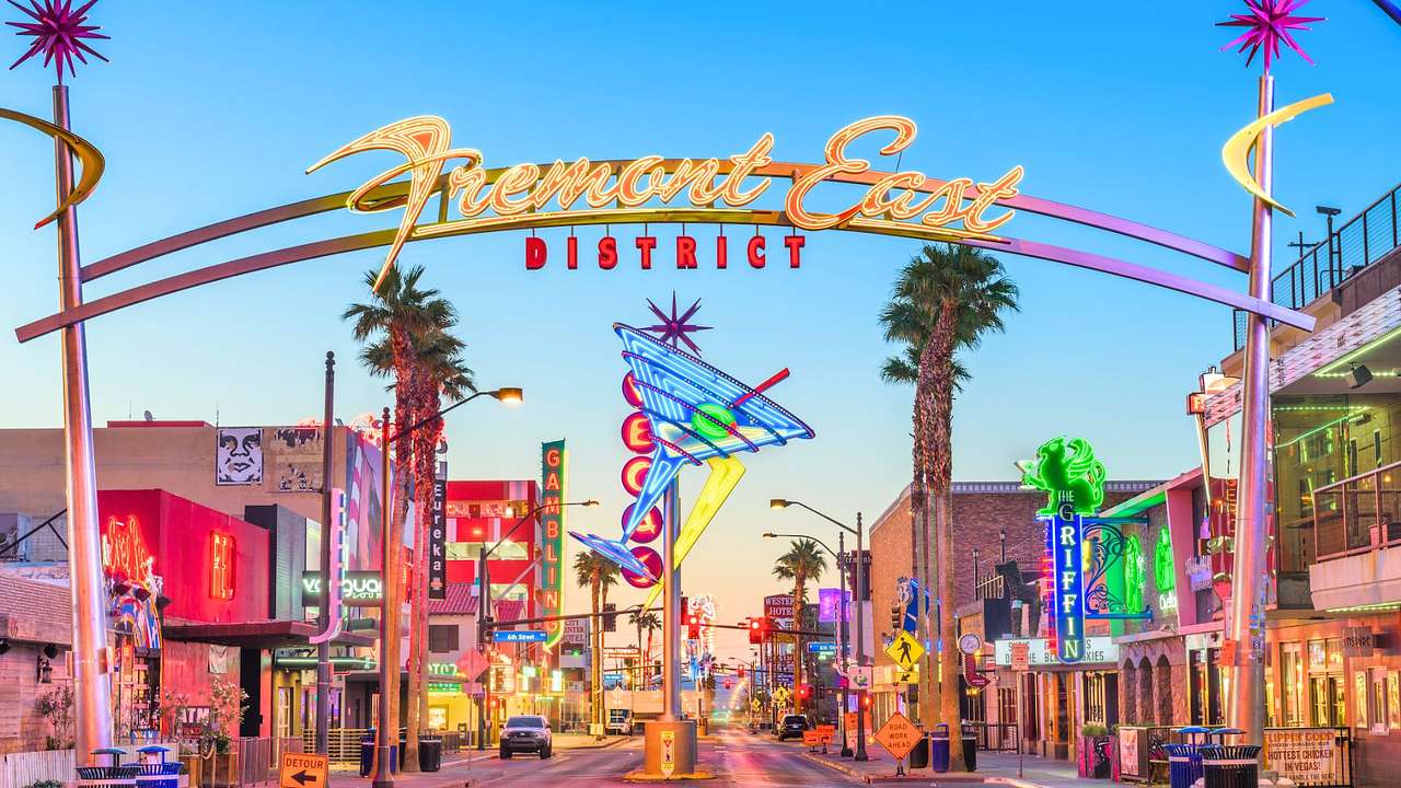 A neon archway that says "Fremont East District" and a large martini glass sign