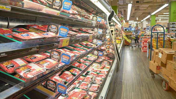 A supermarket with a freezer lined with packaged meat