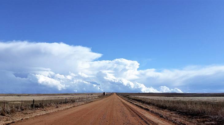 An empty rough road on a cloudy day