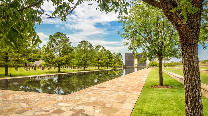 An artificial body of water in the middle of a landscaped area surrounded by trees