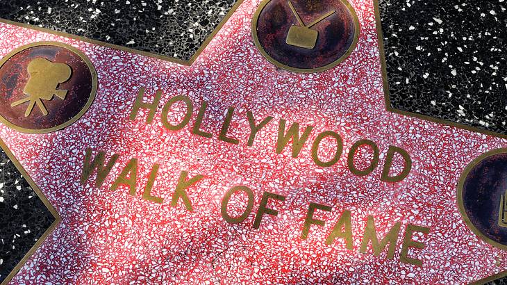A star printed on a marble floor with text saying "Hollywood Walk of Fame"