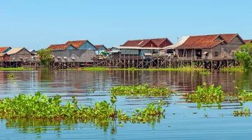 Casas sobre pilotes en un pueblo flotante contra un cielo azul