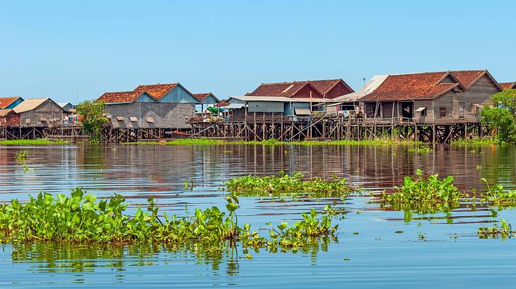 Houses on stilts in a floating village against a blue sky