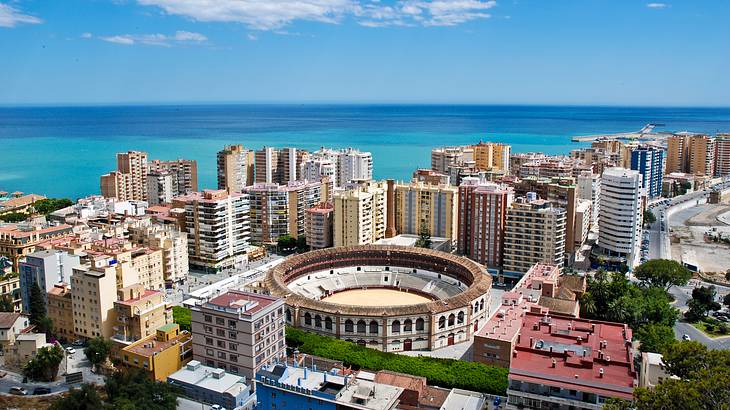 Aerial view of a city with buildings and a round stadium building in the center