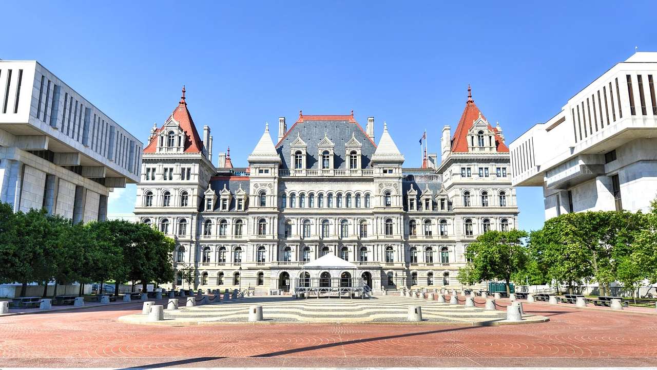 A capitol building with Romanesque Revival architecture under a clear blue sky