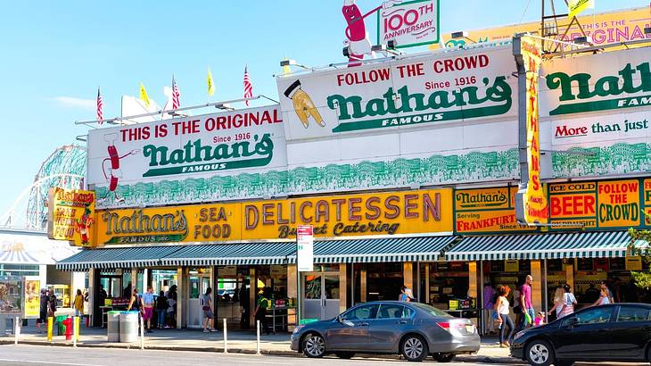 A restaurant building with billboards of "This is the original Nathan's Famous"