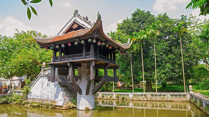 A single-pillar structure elevated amidst a lake with greenery in the background