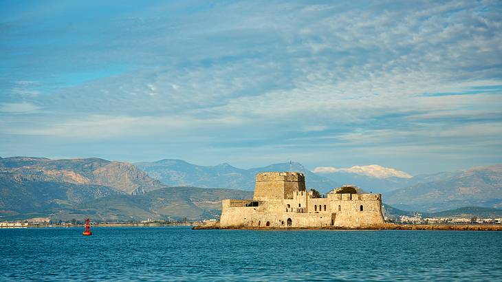 A castle fortress surrounded by water and mountains in the back, Nafplio, Greece