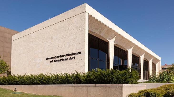 A flat-roofed building with an "Amon Carter Museum of American Art" sign A flat-roofed building with an "Amon Carter Museum of American Art" sign