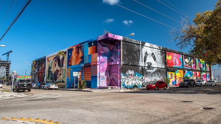 A building on a corner covered in colorful street art and a panda mural