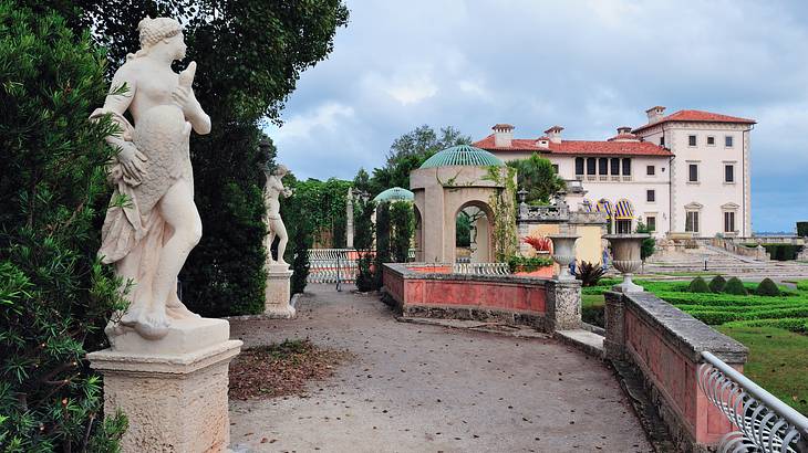 A villa-style house with path and stone statues in front of it