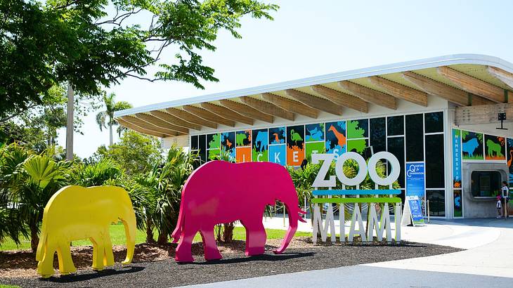 A building with two elephant sculptures and a "Zoo Miami" sign