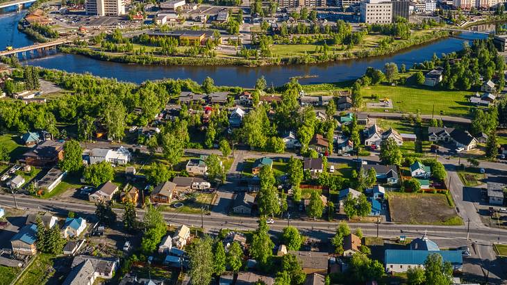 Aerial shot of a residential area with many houses and trees near a river