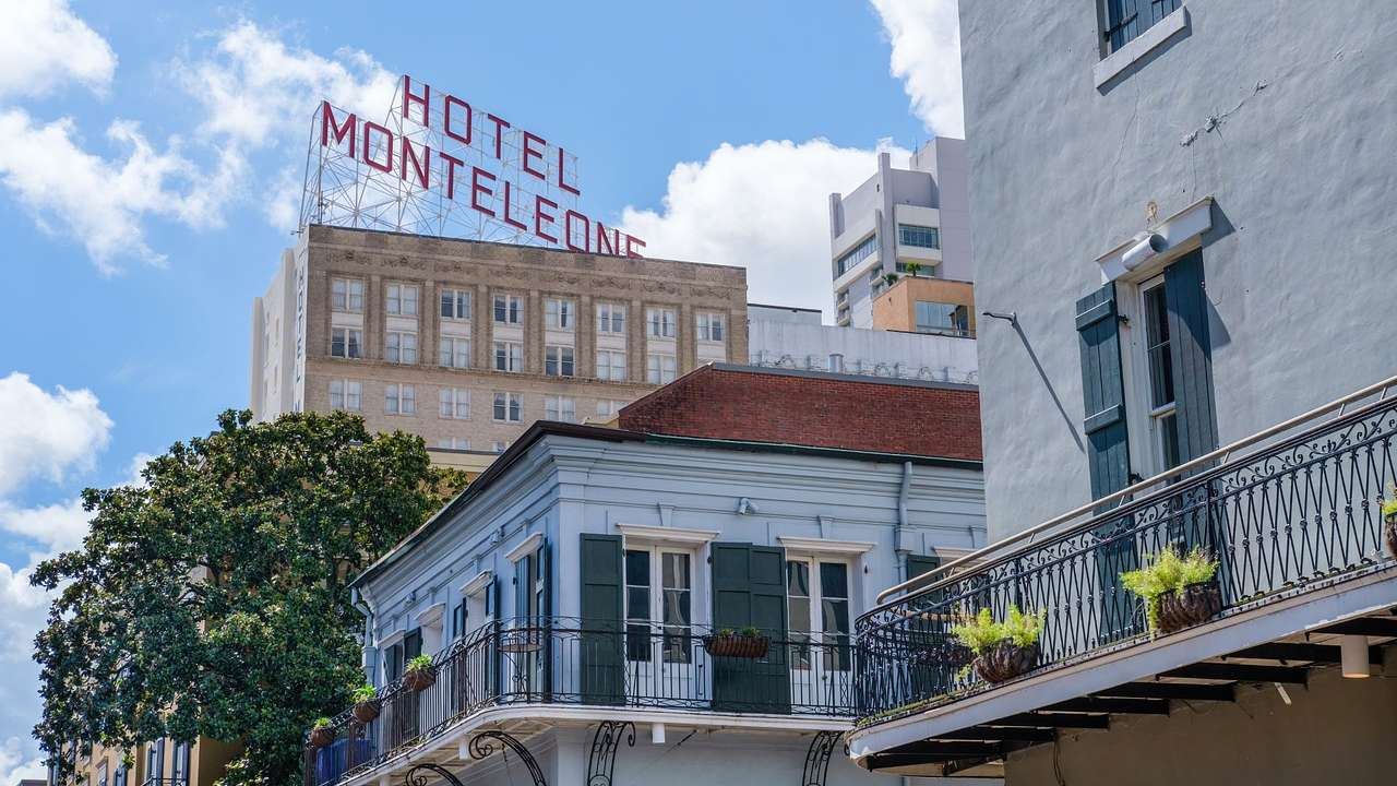 White buildings with balconies and a taller building with a "Hotel Monteleone" sign