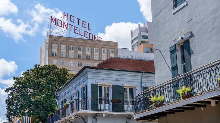 White buildings with balconies and a taller building with a "Hotel Monteleone" sign
