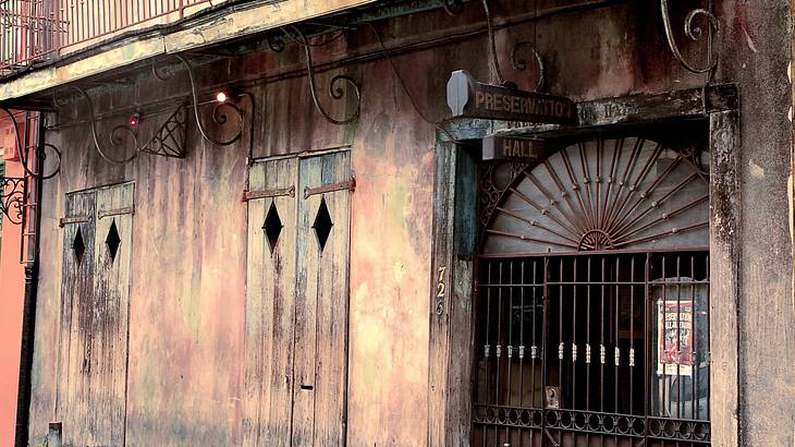 An old rustic house with a balcony and a steel door gate