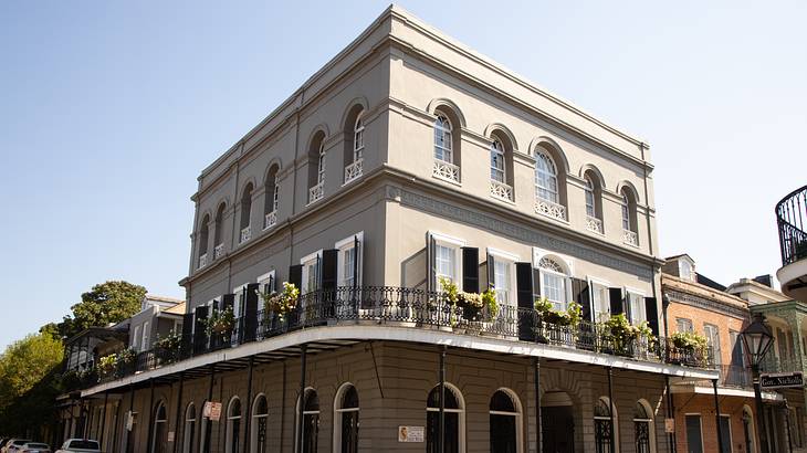 An off-white Baroque-style building with a balcony and many windows