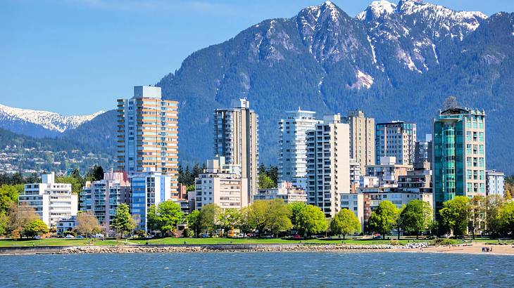 A coastal urban city with tall buildings and a mountain in the background