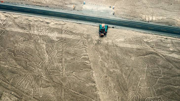 Aerial view of a road going through a desert with lines etched on it