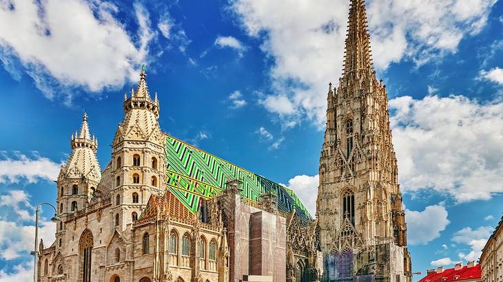 A cathedral with a large spire, two towers, and a green mosaic