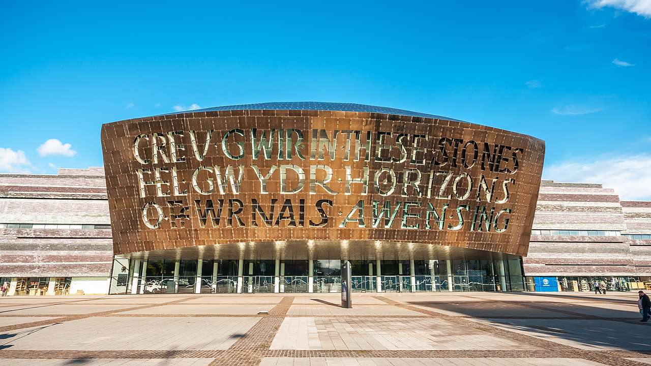 Big writing on a copper sign above an entrance to a massive building