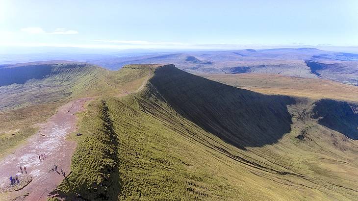 A walking path along a green mountaintop on a sunny day