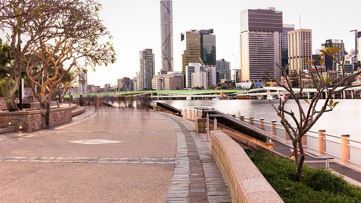 City skyline full of tall buildings along a river from a promenade City skyline full of tall buildings along a river from a promenade
