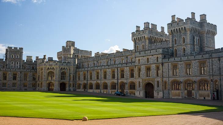 A perfectly manicured green lawn in front of a gigantic castle in the back