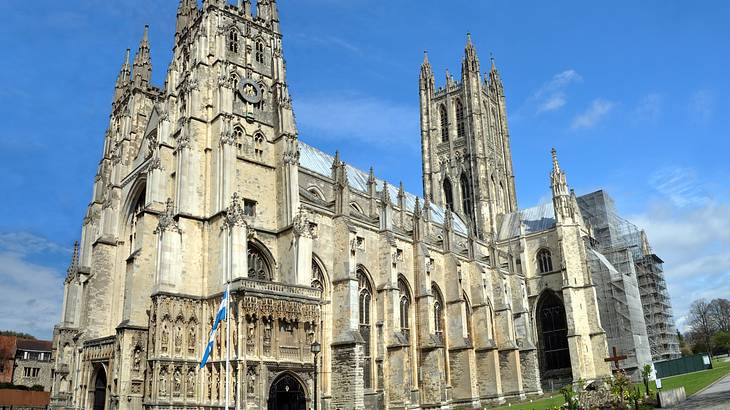 Side view of a cathedral with towers under blue skies with a few clouds