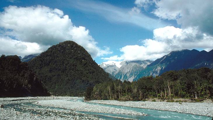 A river broken up over rocks with mountains at the back A river broken up over rocks with mountains at the back