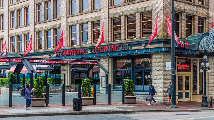 A brick building with a sign that says "Steamworks Brewing Co" next to a street