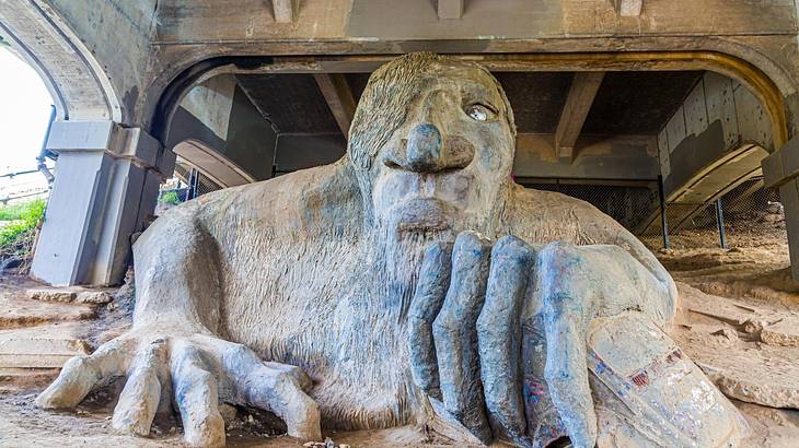 A statue of a troll placed under a bridge