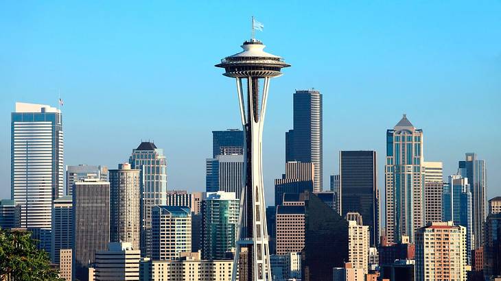 An observation tower on a city skyline surrounded by tall buildings