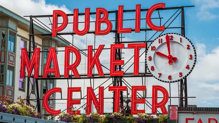 A sign that says "Public Market Center" in red with a white and red clock next to it