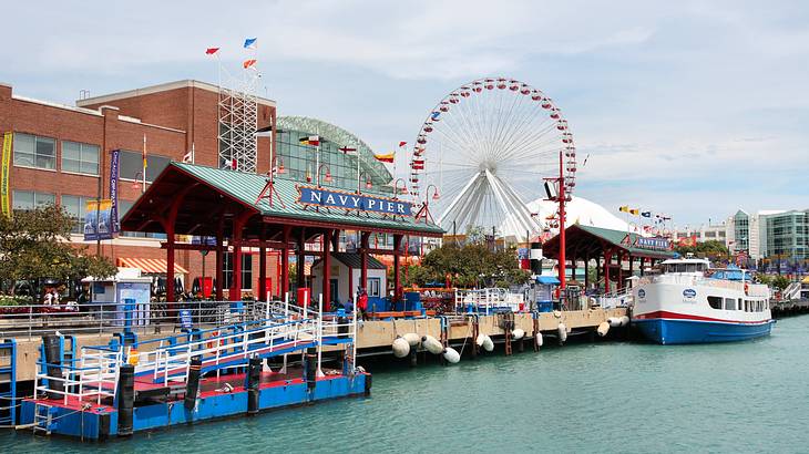 A colorful pier with a boat, a building, and a Ferris wheel in the background