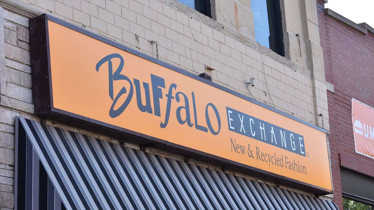 An orange sign on a building that says "Buffalo Exchange"