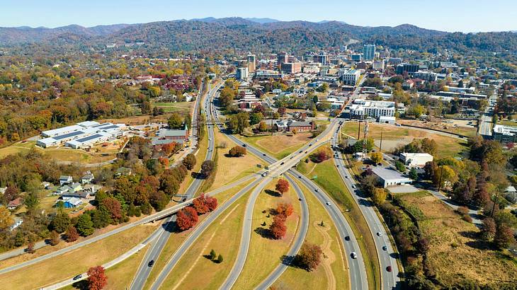 Aerial shot of freeways near trees and houses