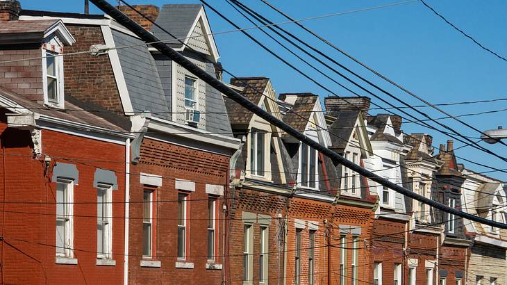 A series of similar bricked residential houses under a blue sky