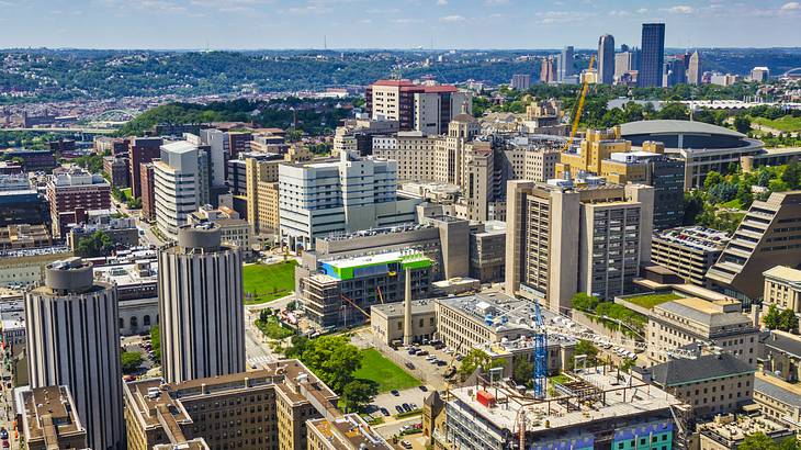 An aerial shot of an urban city under a blue sky with clouds