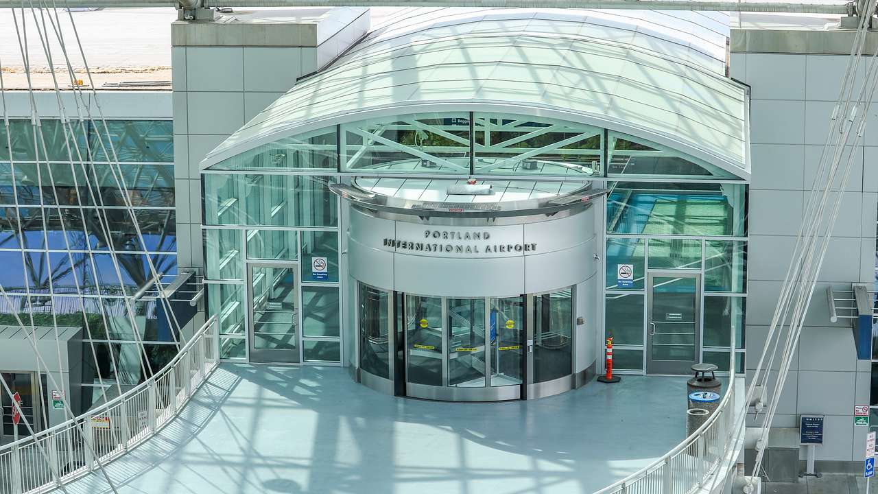 A building with glass panels and a sign saying "Portland International Airport"