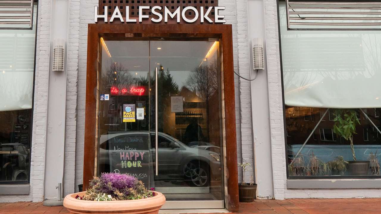 The front of a restaurant with a glass door and a "HalfSmoke" sign