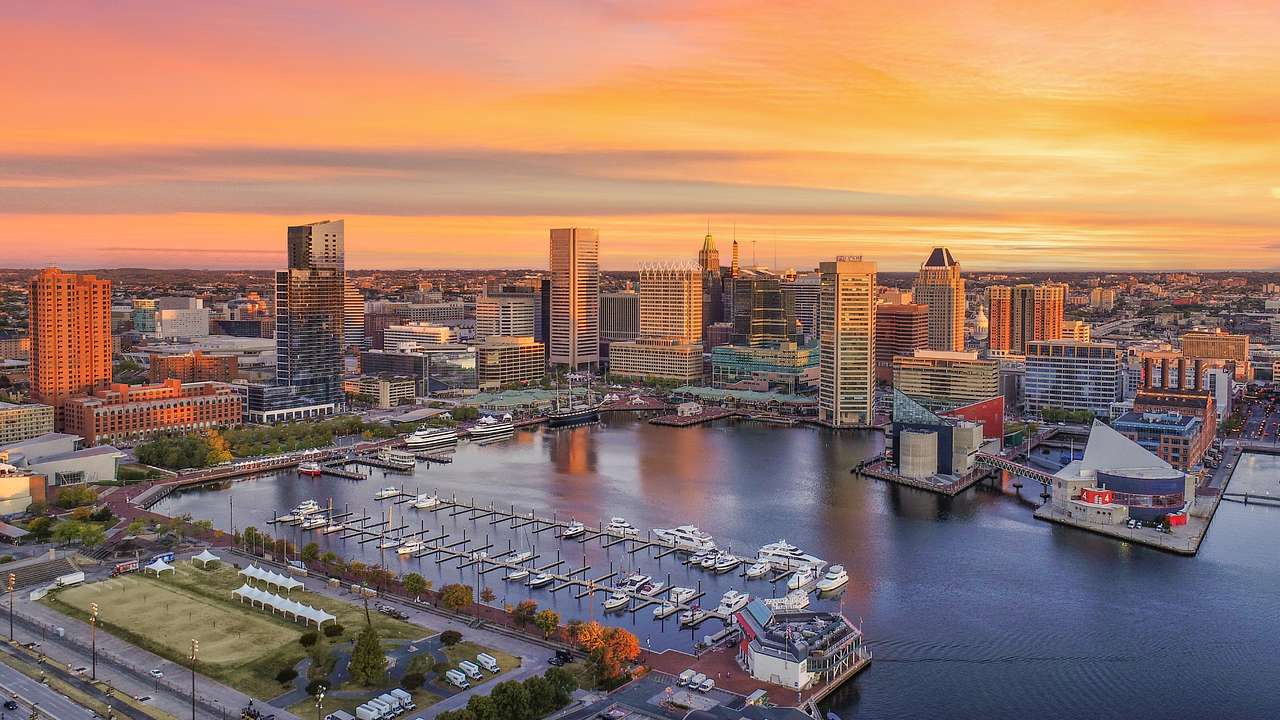 A view over a harbor and city buildings at sunset