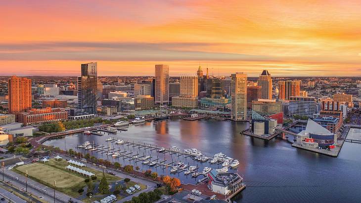 A view over a harbor and city buildings at sunset