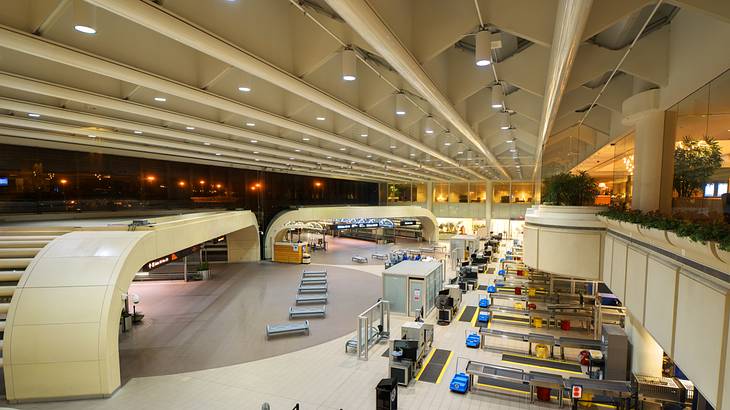 View from the top of the interior of an airport with benches and counters at night