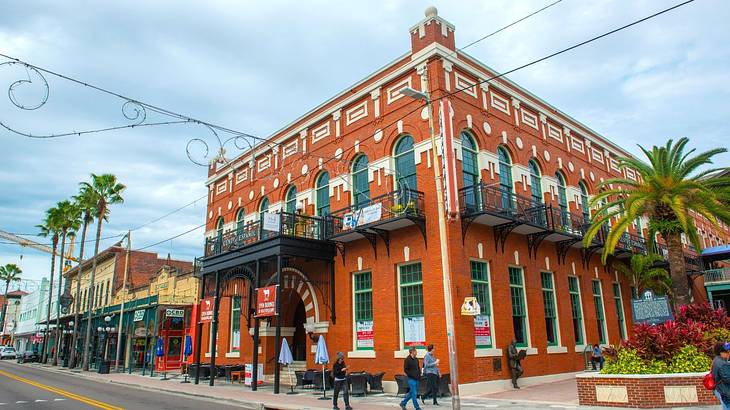 A red-brick building with an arched entrance under a cloudy sky